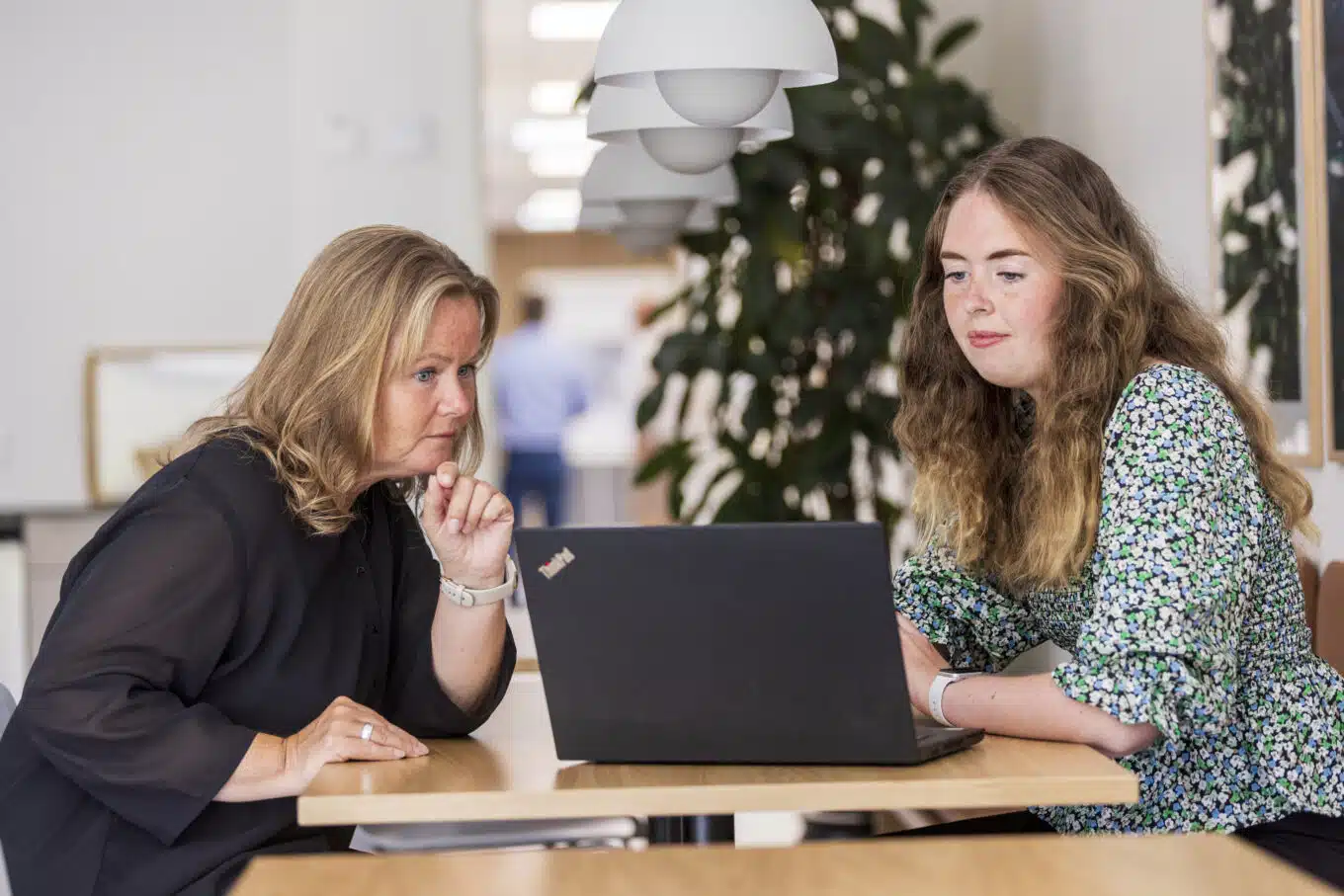 Two female Blue Line employees engaged in eye-level discussion about the development of a product tailored to the customer’s needs.