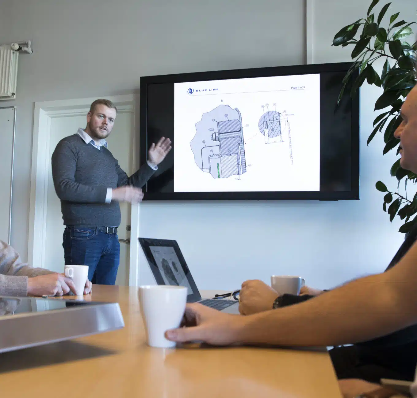 Blue Line employee is holding a meeting and talking about a customized product.